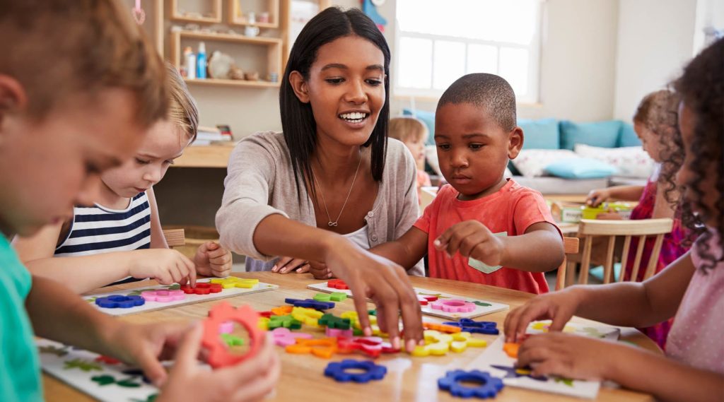 Daycare teacher playing with students