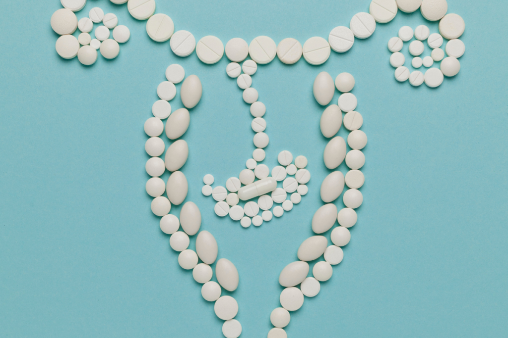 Pills outlining a uterus shape on blue background