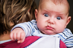 Baby making surprised face, grunting because of gas